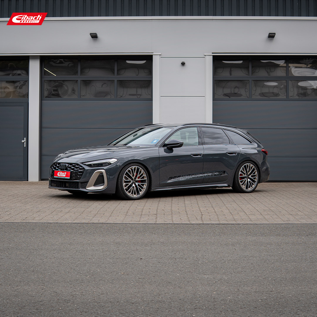 A sleek, dark gray Audi hatchback with sporty wheels and lowered suspension is parked in front of large gray garage doors, featuring an Eibach logo in the upper left corner as an application example.