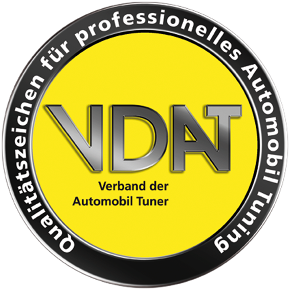 Ein gelb-schwarzes, kreisförmiges Logo mit der Aufschrift „VDAT Verband der Automobil-Tuner“ in der Mitte und dem Schriftzug „Qualitätszeichen für professionelles Automobil-Tuning“ am Rand.